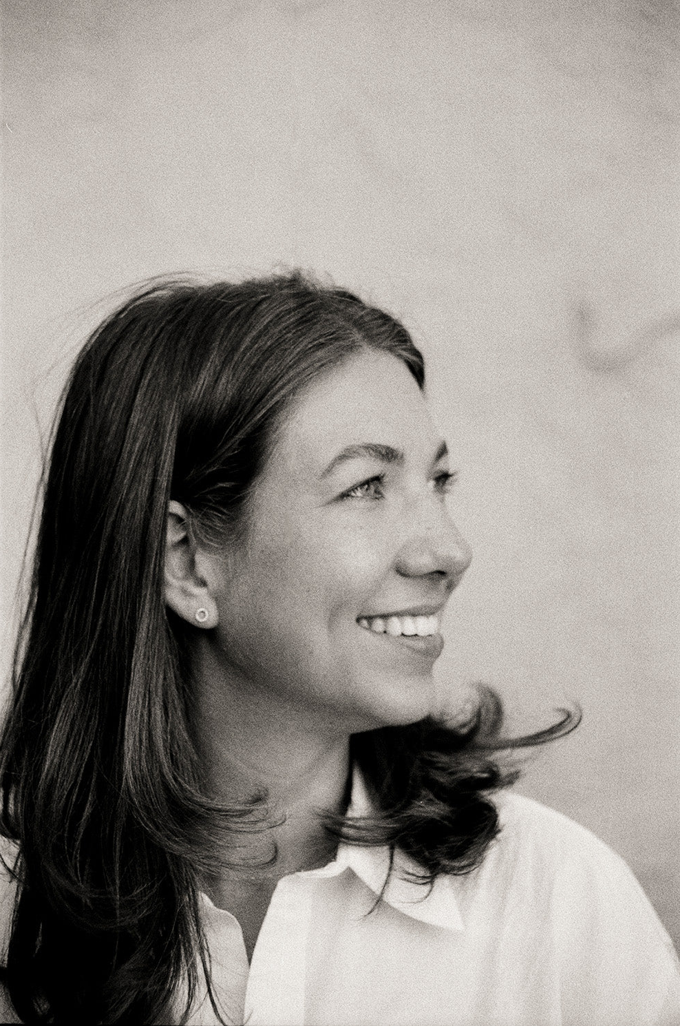 Black and white portrait of a woman with long hair against a plain background